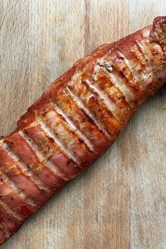 a piece of meat sitting on top of a wooden cutting board