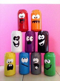 there are many different colored canisters that have faces on them and mouths in the middle