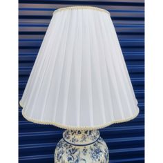 a lamp that is sitting on a blue and white table with a light shade over it