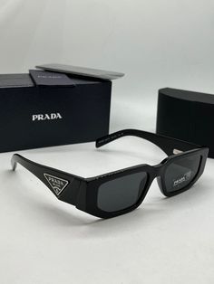 Brand new Prada PR09ZS Sunglasses in Black.Featuring a black rectangular acetate frame with dark grey lenses.Silver metal plaque Prada logos on temples.Measures 54-18-140. Unisex.100% authentic and unworn.Made in Italy.Box, case, cloth and paperwork included. Retail price $560. Prada Aesthetic, نظارات شمسية, Shimla, Prada Sunglasses, Metal Plaque, Girls Dream