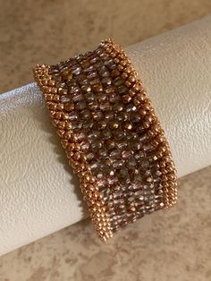 This is a one of kind, Czech fine polish cuff handcrafted with a copper slide clasp. Handmade Bronze Cuff Jewelry, Elegant Brown Cuff Bracelet As Gift, Elegant Brown Cuff Bracelet Gift, Unique Adjustable Rose Gold Bracelet, Elegant Adjustable Brown Cuff Bracelet, Adjustable Unique Rose Gold Bracelets, Adjustable Unique Rose Gold Bracelet, Brown Hand Wrapped Cuff Bracelet For Gift, Artisan Bronze Cuff Bangle Bracelet