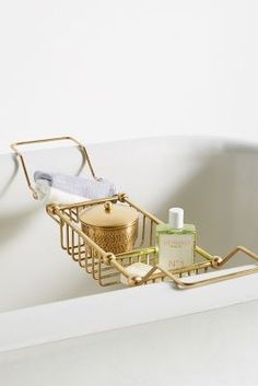 a bathtub with soap and lotion in it, next to a towel rack