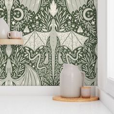 a green wallpaper with an intricate design in the center and two vases on top