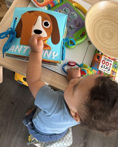 a toddler playing with toys at a table in a playroom or nursery area