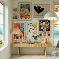 a room with posters on the wall and a table in front of it next to a window