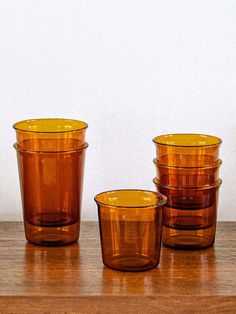 three brown glass cups sitting on top of a wooden table