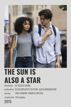 a man and woman standing next to each other in front of a white sign that says the sun is also a star