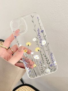 a woman holding up her phone case with flowers on the front and back cover in clear