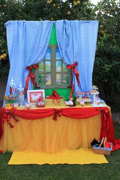 the table is set up outside for an outdoor party with red, yellow and blue decorations