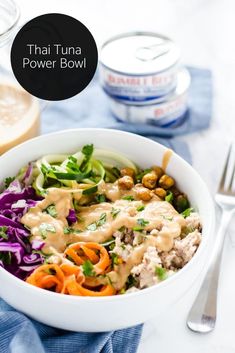 a white bowl filled with food next to a fork and glass of milk on a table