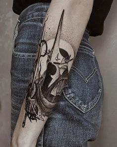 a person with a knife and skull tattoo on their arm