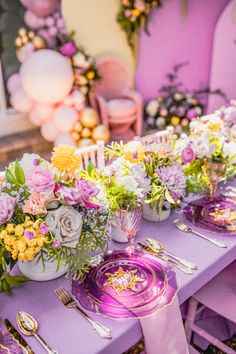 a purple table topped with lots of flowers