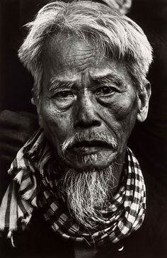 an old black and white photo of a man with long hair, wearing a scarf