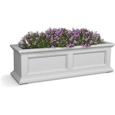 a white planter with purple flowers in it