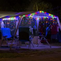 a tent that has some chairs under it with lights on the inside and outside walls