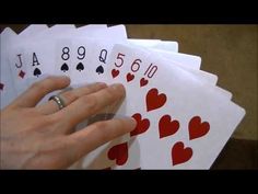 a person holding four playing cards in their hand with the number six on each card