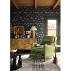 a green recliner chair sitting in front of a window on top of a rug