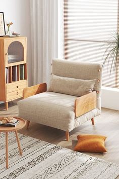 a living room with a couch, coffee table and bookshelf in the corner