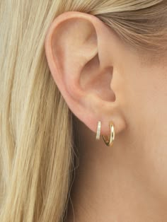 a close up of a woman's ear with two small hoops on it