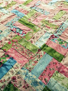 a patchwork quilt with pink, green and blue flowers