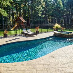 a backyard with a swimming pool surrounded by trees