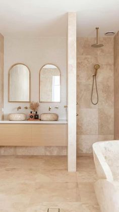 a bathroom with two sinks, mirrors and a bathtub in the middle of it