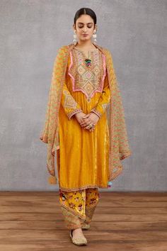 Topaz yellow long kurta with placement geometric motif embroidery. Comes with printed pants and silk organza dupatta.
Component: 3
Printed, Embroidered
Neckline: Round
Sleeve Length: Full
Fabric: Kurta: Velvet, handwoven chanderi,  cotton silk, voile; Pant: velvet, cotton silk, voile, Silk Organza; Dupatta: Pure silk organza, cotton silk, handwoven chanderi
Color: Yellow
Side slit
Split neck
Tassel detail
 - Aza Fashions Yellow Kurta, Velvet Embroidery, Indian Bride Outfits, Velvet Dress Designs, Simple Kurta Designs, Pakistani Wedding Outfits, Organza Dupatta, Embroidery Suits, Stylish Dress Designs