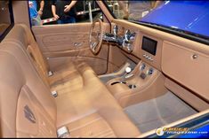 the interior of a car with people standing around