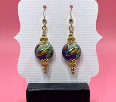 These Tensha purple mosaic earrings have a vintage feel to them. I accented the Tensha beads with gold vermeil spacer beads, gold vermeil bead caps and small round gold filled beads. They measure approximately 1 3/4 inches from the top of the gold filled earwire. Please note that images are enlarged to show detail. Click here to see other earrings in my shop: https://www.etsy.com/shop/JewelryDesignsByRita?section_id=14765680 I have been designing and making jewelry since 2010. I use only the highest quality materials such as Swarovski crystals, Swarovski pearls, gemstones, sterling silver, Gold Vermeil, gold filled components and artisan made lampwork beads. If you have any questions as you browse, please feel free to ask. Self-Representing Artist in Jewelry Design, Member #3879 Purple Gemstone Earrings With Round Beads, Purple Earrings With Dangling Round Beads, Purple Faceted Beaded Round Earrings, Purple Earrings With Faceted Round Beads, Purple Polished Round Bead Jewelry, Swarovski Pearls, Bead Caps, Lampwork Beads, Spacer Beads