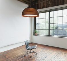 an empty room with a chair and large window