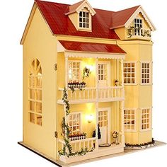 a doll house with lights and decorations on the front porch, windows, and balconies