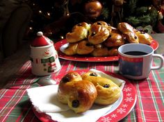 a table topped with pastries next to a cup of coffee and a christmas tree