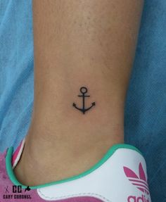 a small anchor tattoo on the ankle