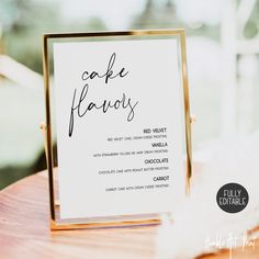 a table with a sign that says cake flavors on it and some feathers in the background