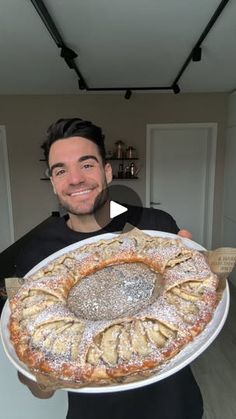 a man holding a large plate with some food on it and smiling at the camera