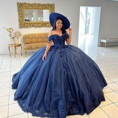 a woman wearing a blue dress and hat in a room with white tile flooring