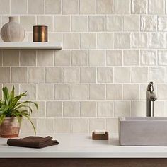 a bathroom with a sink, mirror and shelves on the wall next to each other