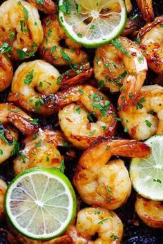 shrimp with limes and lemon wedges in a skillet