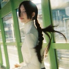 a woman with long hair is walking down the street