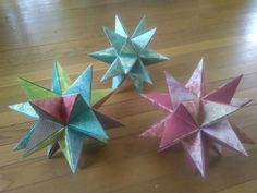 three origami stars sitting on top of a wooden floor