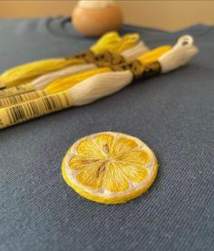 an orange cut in half sitting on top of a blue table cloth next to eggs