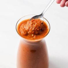 a spoon in a small glass jar filled with sauce