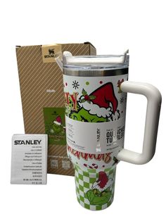 a coffee cup with santa claus on it next to a cardboard box and some other items