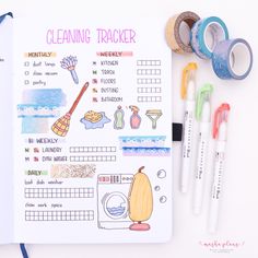 an open planner with washi tape and markers next to it on a white surface