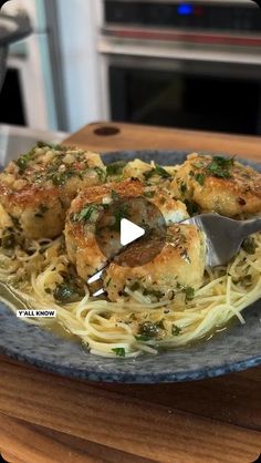 a blue plate topped with pasta covered in sauce and meatballs on top of it