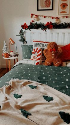 a teddy bear sitting on top of a bed in a room with christmas decorations around it