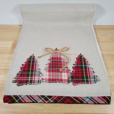 three christmas trees on a white towel with red and green plaid