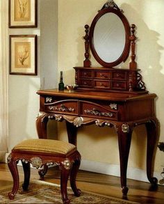 an antique dressing table with mirror and stool