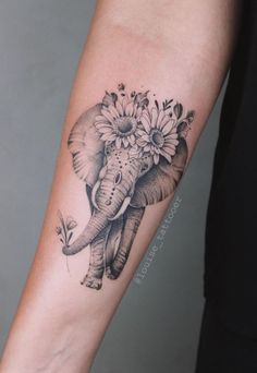 an elephant with sunflowers on it's head is shown in black and white