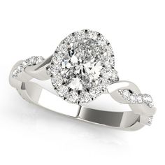 a white gold ring with an oval shaped diamond in the center, surrounded by round diamonds